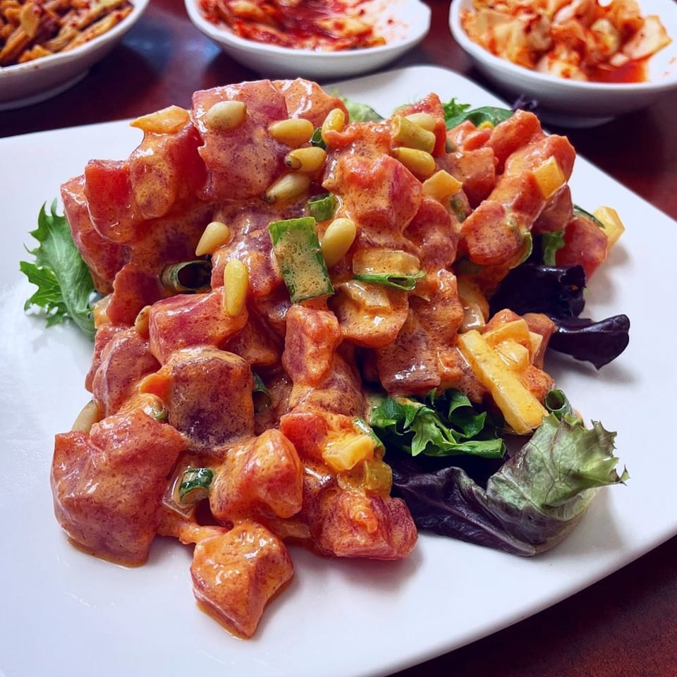 Kim Chee Restaurant's spicy tuna poke with pine nuts, green onions, and bell peppers on lettuce.